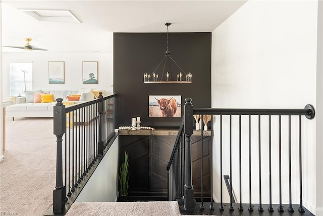 stairs with carpet flooring and an inviting chandelier