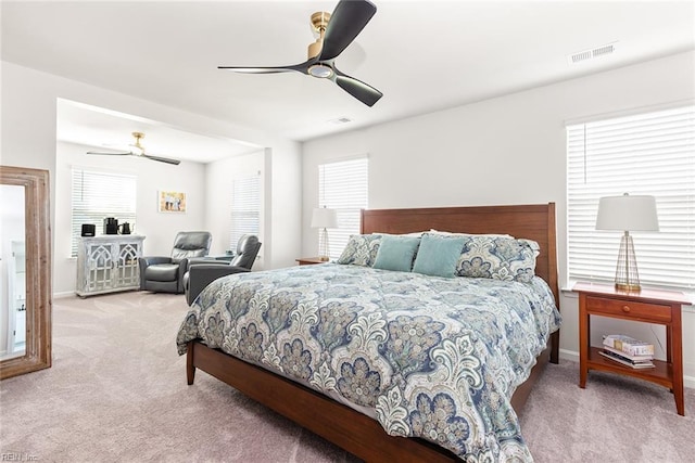 bedroom with multiple windows, ceiling fan, and carpet