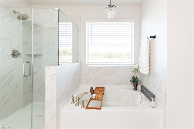 bathroom with shower with separate bathtub and plenty of natural light