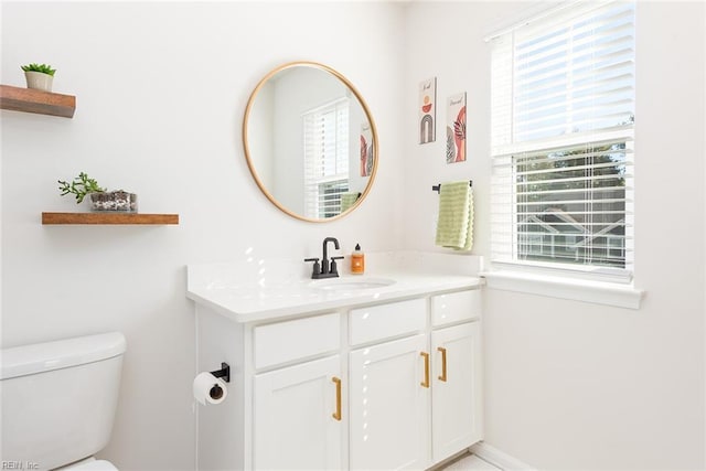 bathroom with vanity, a healthy amount of sunlight, and toilet