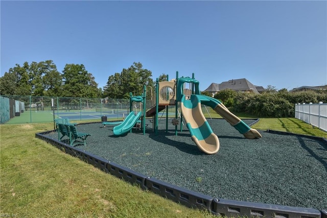 view of playground featuring a yard and tennis court