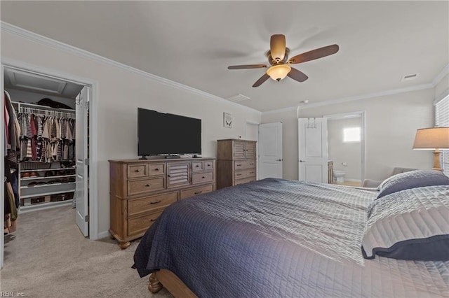 bedroom with ornamental molding, a walk in closet, light colored carpet, ceiling fan, and a closet