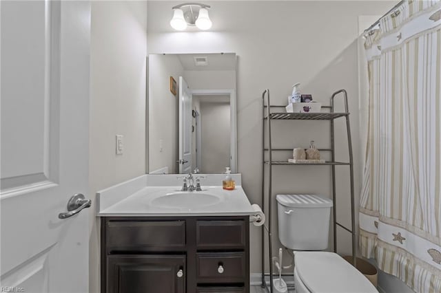 bathroom with vanity, curtained shower, and toilet