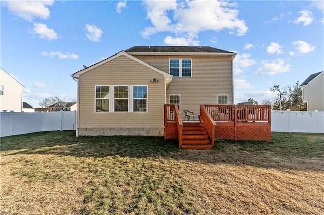 back of property featuring a wooden deck and a lawn