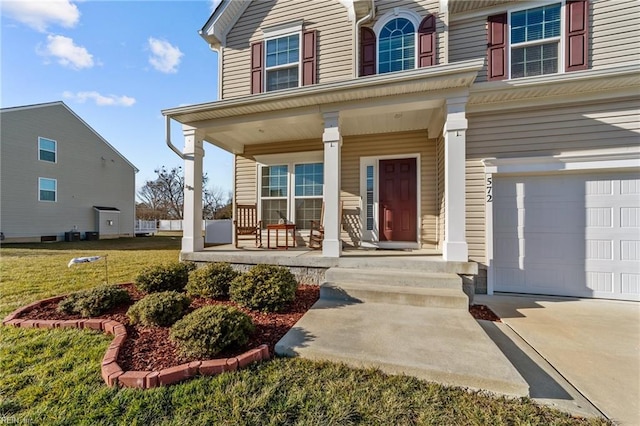 property entrance with a garage, a lawn, and covered porch