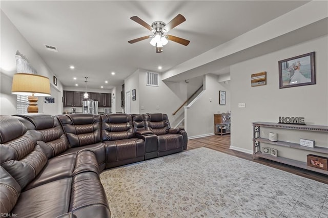 living room featuring dark wood-type flooring and ceiling fan