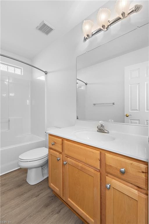 full bathroom with vanity, hardwood / wood-style flooring, shower / bathtub combination, and toilet