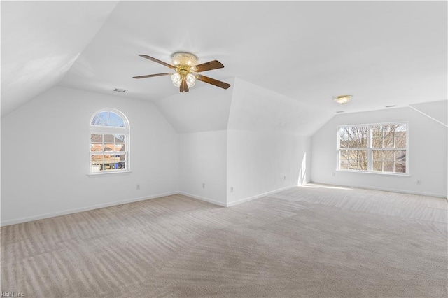 additional living space featuring ceiling fan, light colored carpet, and lofted ceiling