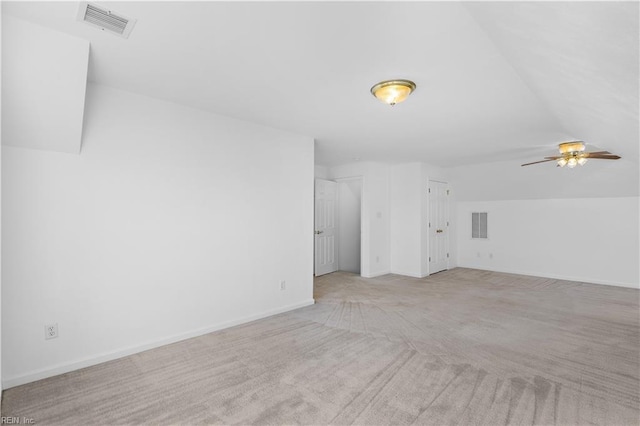 unfurnished living room featuring vaulted ceiling, light colored carpet, and ceiling fan