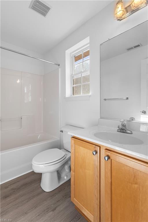 full bathroom with wood-type flooring, toilet, bathing tub / shower combination, and vanity