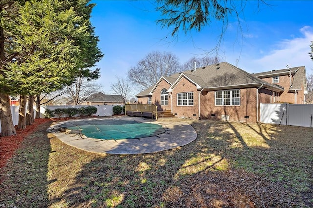 view of swimming pool featuring a wooden deck, a patio, and a lawn