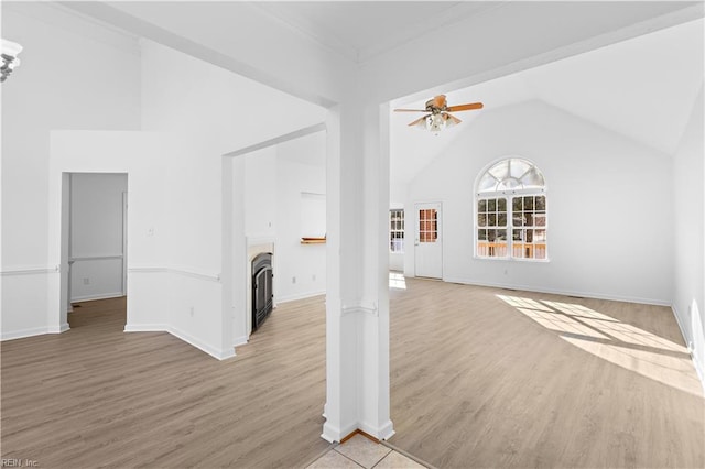 unfurnished living room featuring ceiling fan, vaulted ceiling, and light hardwood / wood-style flooring