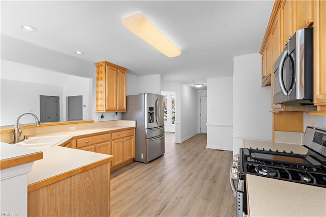 kitchen featuring sink, light hardwood / wood-style flooring, stainless steel appliances, light brown cabinetry, and kitchen peninsula