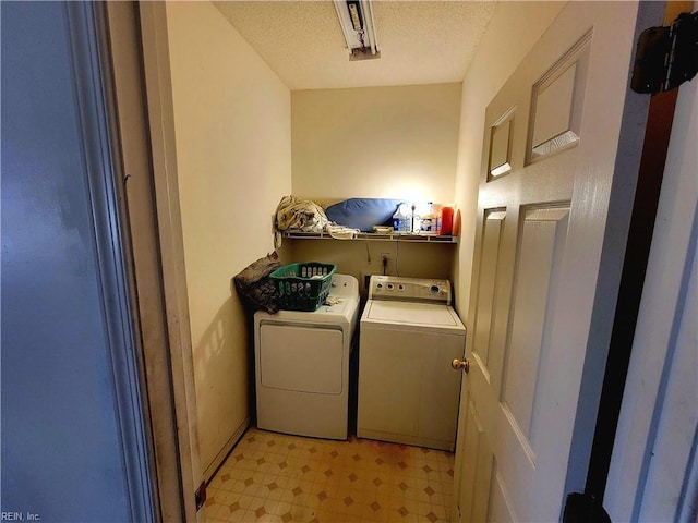 laundry area with a textured ceiling and washer and clothes dryer