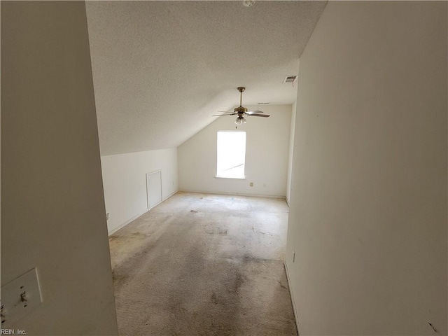 bonus room featuring lofted ceiling, ceiling fan, light carpet, and a textured ceiling