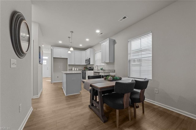 dining space featuring sink and light hardwood / wood-style floors