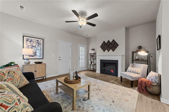 living room with wood-type flooring and ceiling fan