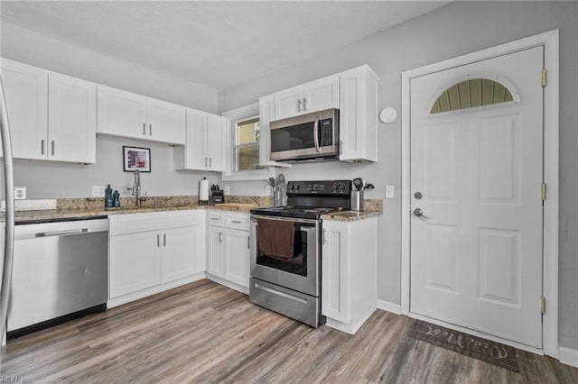 kitchen with white cabinetry, sink, hardwood / wood-style flooring, and appliances with stainless steel finishes