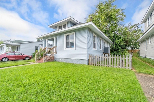 bungalow with a front lawn and central air condition unit