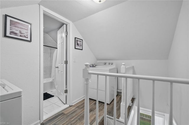 interior space with hardwood / wood-style flooring, vaulted ceiling, and shower / bath combo with shower curtain