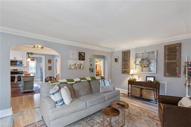 living room with crown molding and light hardwood / wood-style flooring