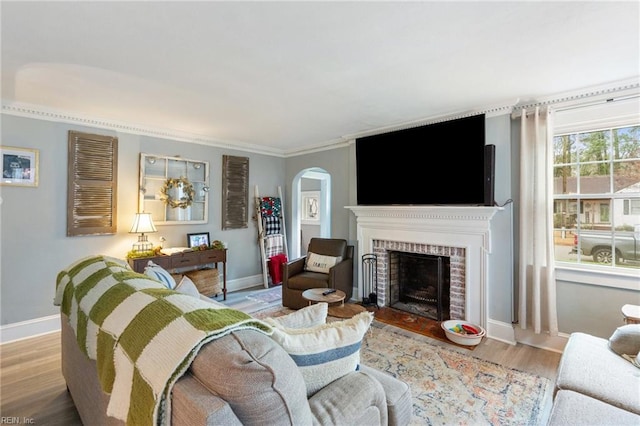 living room featuring a brick fireplace and light hardwood / wood-style flooring