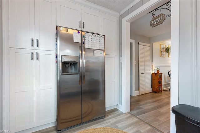 kitchen featuring white cabinetry, stainless steel refrigerator with ice dispenser, and light hardwood / wood-style flooring