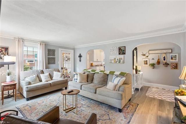 living room with crown molding and light hardwood / wood-style floors