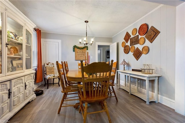 dining area featuring an inviting chandelier, dark hardwood / wood-style floors, and crown molding