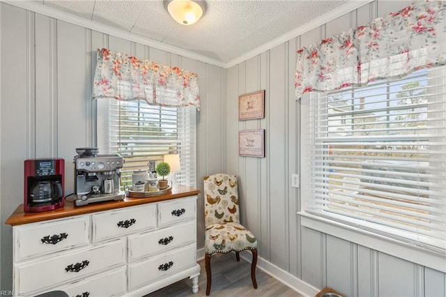 living area with hardwood / wood-style floors and ornamental molding