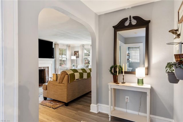 living room with hardwood / wood-style flooring and a brick fireplace