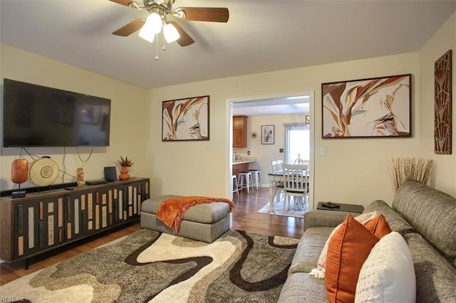 living room with ceiling fan and dark hardwood / wood-style flooring