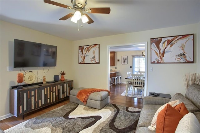 living room featuring ceiling fan and dark hardwood / wood-style flooring