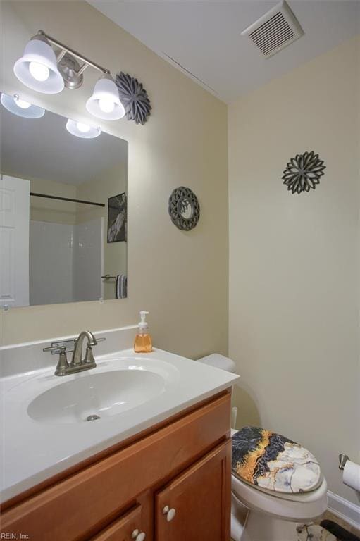 bathroom featuring walk in shower, vanity, and toilet