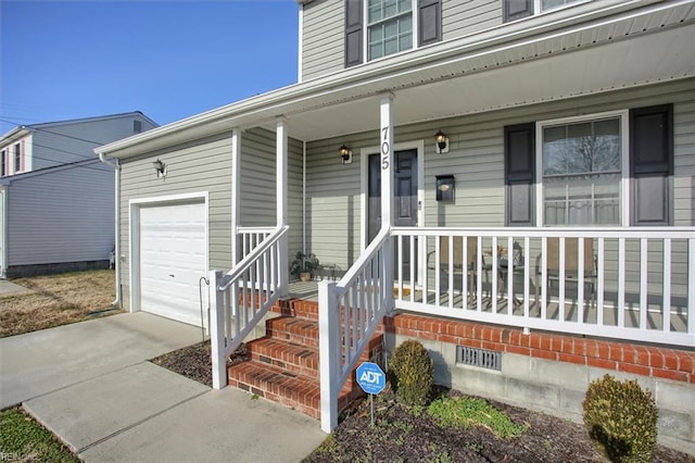 property entrance with a garage and covered porch