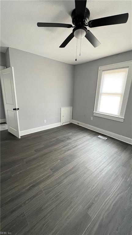 spare room featuring dark hardwood / wood-style flooring and ceiling fan