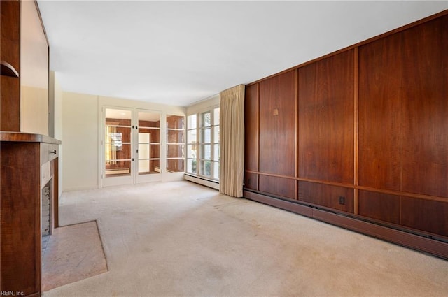 unfurnished living room featuring a baseboard heating unit and light colored carpet