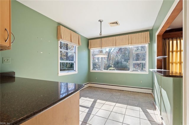 kitchen with hanging light fixtures, a baseboard radiator, dark stone counters, and light tile patterned flooring