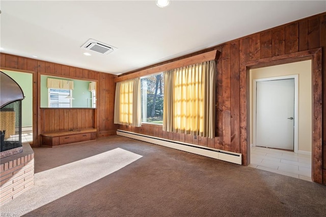 unfurnished living room with carpet floors, wooden walls, and baseboard heating