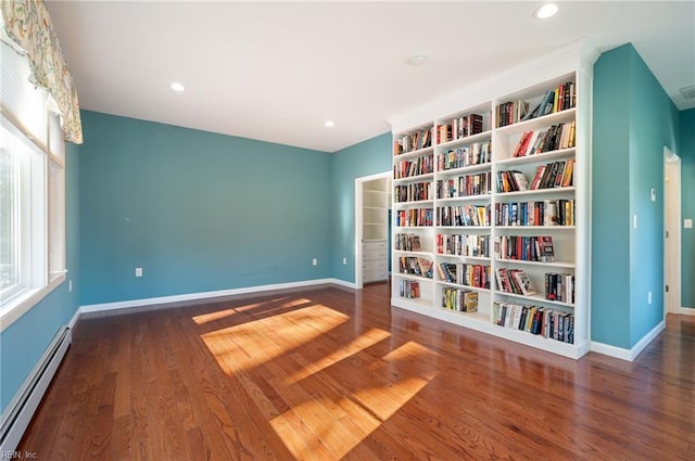 unfurnished room featuring dark wood-type flooring and baseboard heating