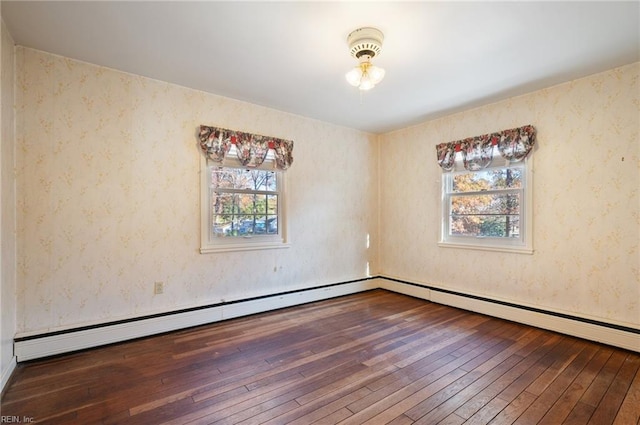 empty room featuring wood-type flooring and baseboard heating