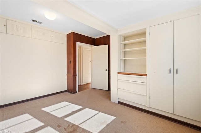 unfurnished bedroom featuring light carpet and two closets