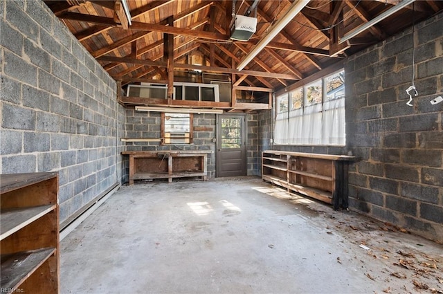 misc room featuring a baseboard heating unit, vaulted ceiling, and concrete flooring