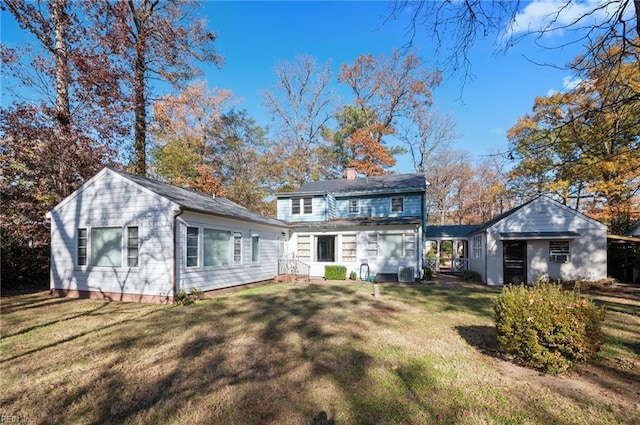 rear view of house with central AC and a lawn