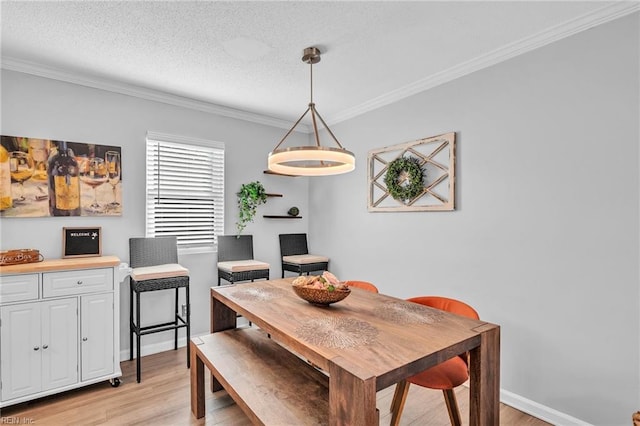 dining room with crown molding, a textured ceiling, and light hardwood / wood-style floors