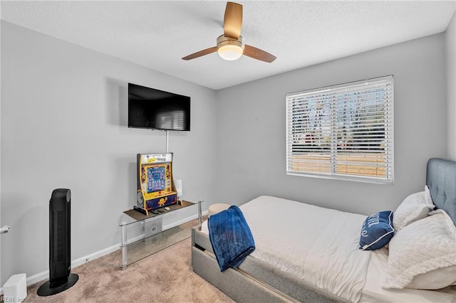 carpeted bedroom with ceiling fan and a textured ceiling