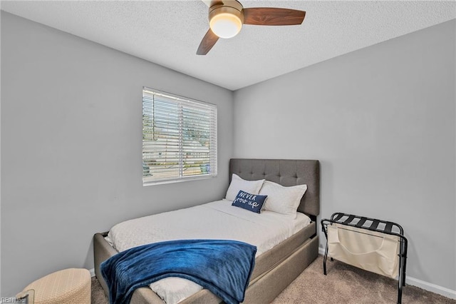 carpeted bedroom featuring ceiling fan and a textured ceiling