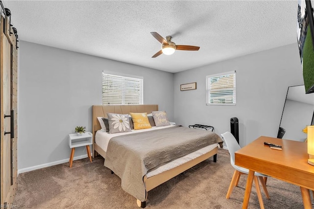 carpeted bedroom featuring a textured ceiling, a barn door, and ceiling fan