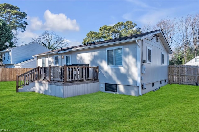 rear view of property with a wooden deck and a yard