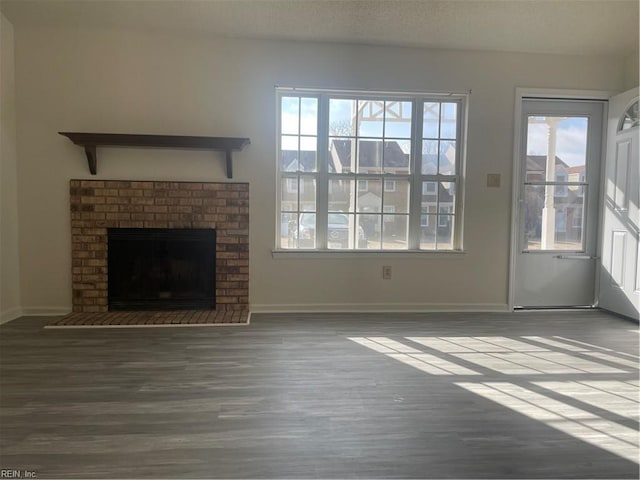 unfurnished living room with plenty of natural light, a fireplace, and hardwood / wood-style floors